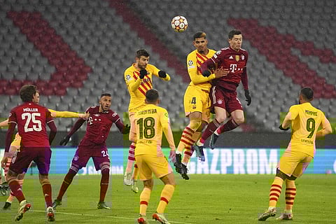 Bayern's Robert Lewandowski, right on the air, heads the ball next to Barcelona's Ronald Araujo during the Champions League group E soccer match between Bayern Munich and FC Barcelona. (Photo | AP)