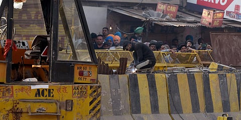 Workers working on the protest site as a part of security enhancement during an ongoing farmer's protest against the new farm laws, at the Singhu border. (Photo| ANI)
