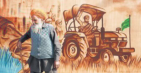 An old farmer walks past a painting showcasing rural India at Singhu border in New Delhi. (Photo | Shekhar Yadav, EPS)