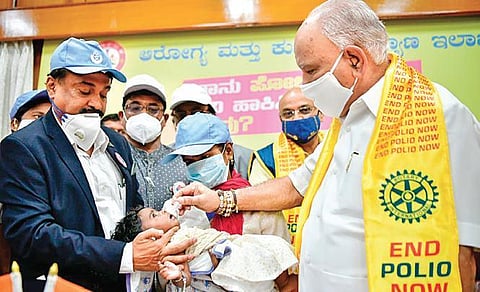 Chief Minister B S Yediyurappa administers polio vaccine to a baby at his home office Krishna, in Bengaluru on Sunday