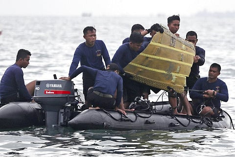 Indonesian Navy divers pull out a part of an airplane out of the water during a search operation for a Sriwijaya Air passenger jet. (Photo | AP)