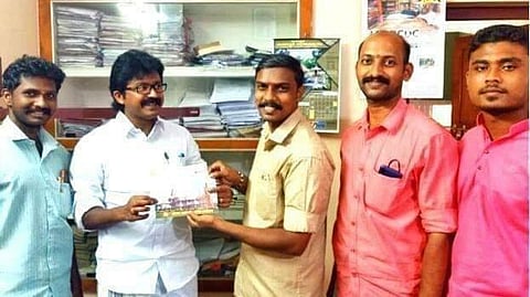 Congress MLA from Perumbavoor in Kerala, Eldhose Kunnappilly holding a card with the image of a building (Photo | Twitter)