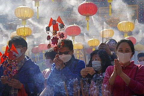 Worshippers wearing face masks to protect against the spread of the coronavirus, burn joss sticks as they pray (Photo | AP)