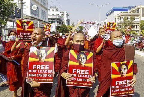 Buddhist monks display pictures of deposed leader Aung San Suu Kyi during a street march against the military coup in Mandalay, Myanmar. (Photo | AP)