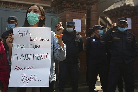 A Nepalese woman holds a placard against a proposed rule which restricts foreign travel for women under 40 years. (Photo | AP)