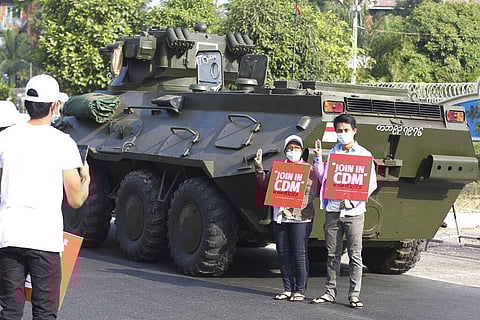 Anti-coup protesters flash the three-fingered salute and hold signs that read 'Join in CDM (Civil Disobedience Movement)'. (Photo | AP)