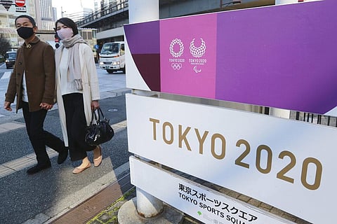 People walk by signage to promote the Olympic Games, in Tokyo. (Photo | AP)