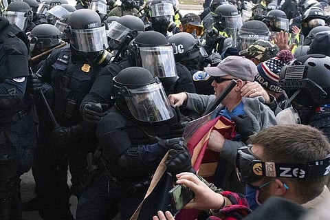 Capitol police officers in riot gear push back demonstrators who try to break a door of the U.S. Capitol. (Photo | AP)