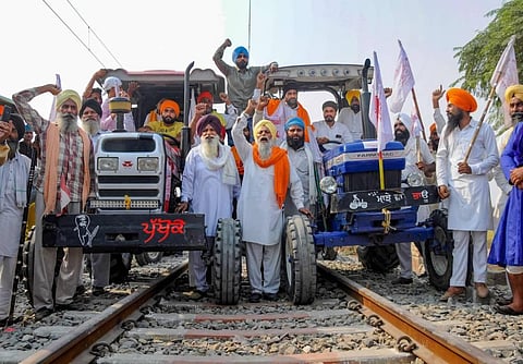 Farmers raise slogans as they block train tracks with tractors on the twentieth day of their ongoing 'Rail Roko' protest over recent farm reform Laws. (Photo | PTI)