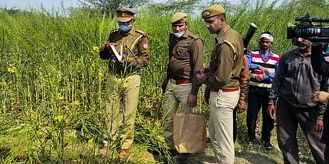 Police personnel investigate at the site where bodies of two minor Dalit girls were found in a field and another in critical condition (Photo | PTI)