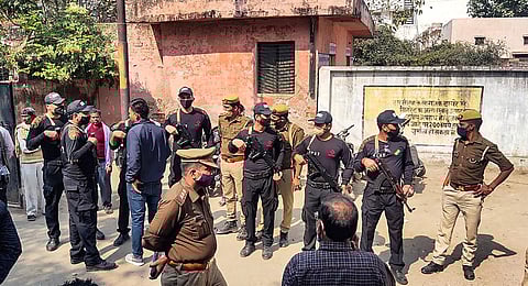 Security personnel stand guard during post-mortem of two minor Dalit girls, who were found dead in a field, near Baburaha village in Unnao district. (Photo | PTI)