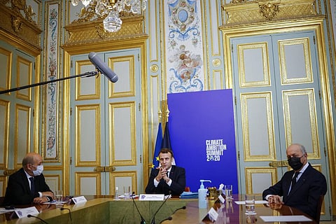 French President Emmanuel Macron (C) flanked by French Foreign Minister Jean-Yves Le Drian (L), and President of the French Constitutional Council Laurent Fabius (R) (Photo | AP)