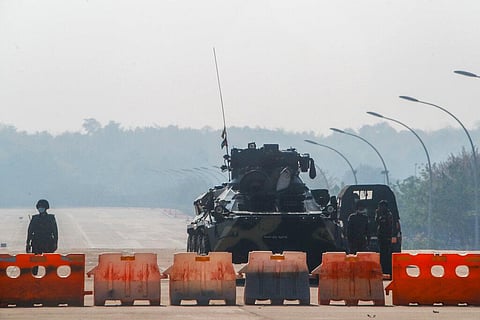 Myanmar's soldiers stand guard at a roadblock manned with an armored vehicle in a road leading to the parliament building Tuesday. (Photo | AP)