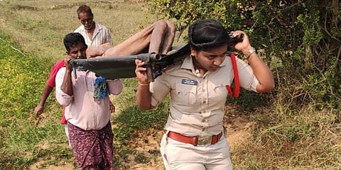 Kasibugga SI Sirisha carrying the body from the outskirts of Adavi Kotturu village in AP’s Srikakulam district.