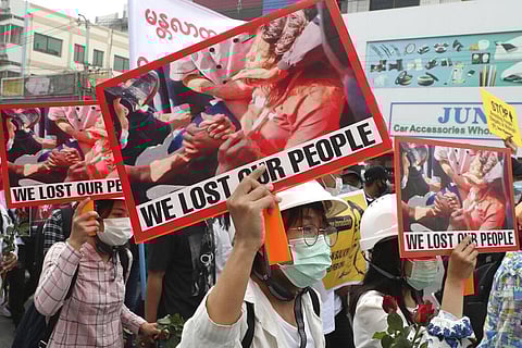 Anti-coup protesters hold an image of Mya Thwet Thwet Khine with a sign that reads 'We Lost Our People' during an anti-coup protest rally in Mandalay, Myanmar. (Photo | AP)