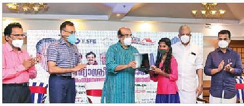 Finance Minister Thomas Isaac distributes a laptop to a student