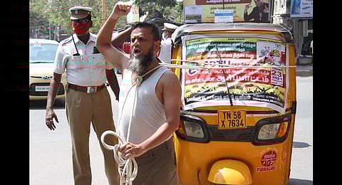 A protestor pulling the auto with a rope, condemning the petrol and diesel price hike at Collectorate in Madurai. (Photo | K K Sundar, EPS)