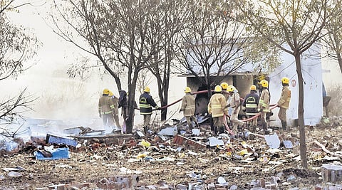 Fire and rescue services personnel putting out a fire following a blast at a cracker unit Kalayarkuruchi village near Sivakasi
