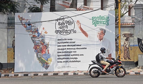 A state government hoarding covers the wall paintings done as part of Arteria wall project near PMG Junction | B P Deepu