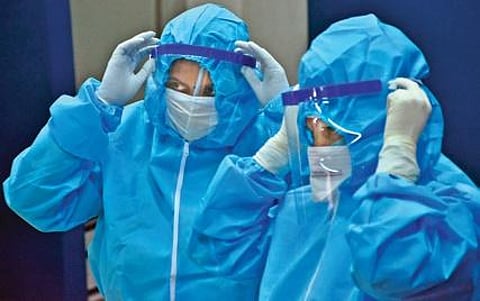 Health workers in PPE kits.