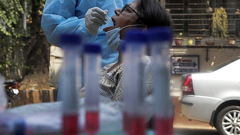 A health worker collects mouth swab