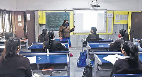 Students listen to a teacher at a government school as physical attendance restarted for more classes. (Photo | Parveen Negi, EPS)