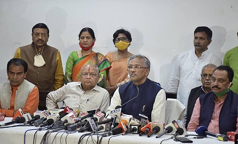 Uttarakhand CM Trivendra Singh Rawat (C_ addresses a press conference after tendering his resignation formally to Governor Baby Rani Maurya in Dehradun Tuesday March 9 2021. (Photo | PTI)