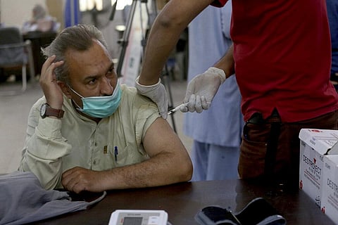 A man receives a Sinopharm coronavirus vaccine from a health worker at a vaccination center, in Karachi, Pakistan. (Photo | AP)