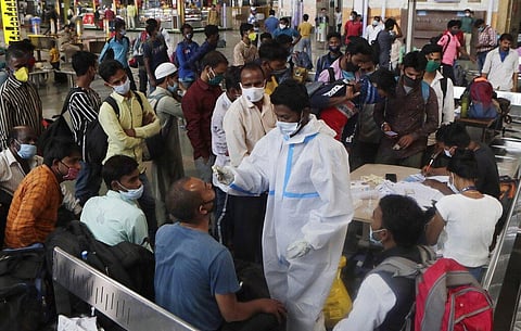 Commuters who arrived by long distance trains wait to test for COVID- 19 at the Chhatrapati Shivaji Maharaj Terminus in Mumbai. (Photo | AP)