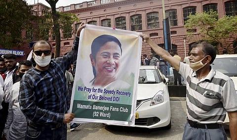 Trinamool Congress supporters pray for the speedy recovery of party chief and West Bengal CM Mamata Banerjee outside SSKM hospital in Kolkata. (Photo | PTI)