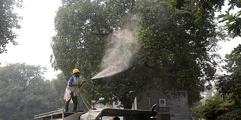 Municipal corporation worker sprinkles water on trees to settle the dust in New Delhi. (File Photo | Shekhar Yadav, EPS)