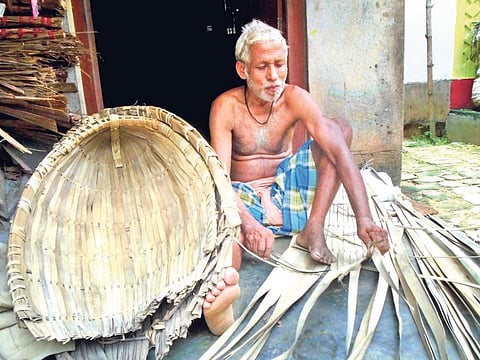 An artisans makes an umbrella from palm leaves I Express