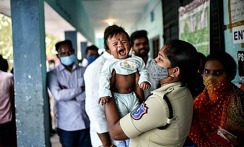 Policewoman pacify crying infants, while their parents cast their vote at polling booths in Hyderabad | Vinay Madapu