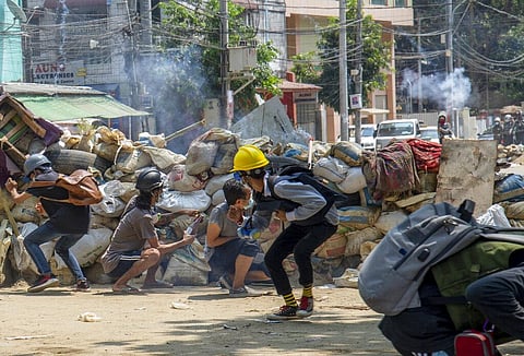 Armed riot policemen charge after firing teargas a rubber bullets as anti-coup protesters abandon their makeshift barricades and run in Yangon, Myanmar Tuesday, March 16, 2021. (Photo | AP)