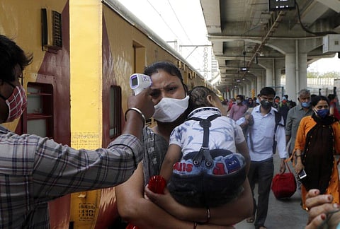 A health worker checks the temperature of passengers as they screen people for COVID-19 tests at a long distance train station in Mumbai. (Photo | AP)