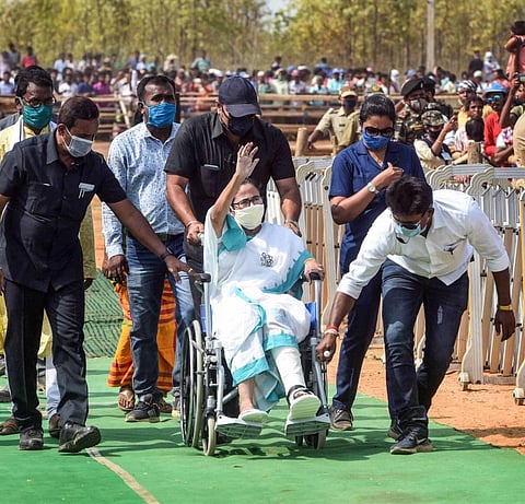 West Bengal Chief Minister and TMC leader Mamata Banerjee on a wheel-chair arrives to address an election campaign rally for the upcoming state assembly polls. (Photo | PTI)