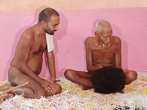 Nemisagar Maharaj (right) is being attended by a young monk at Varur near Hubballi (Photo | D Hemanth)