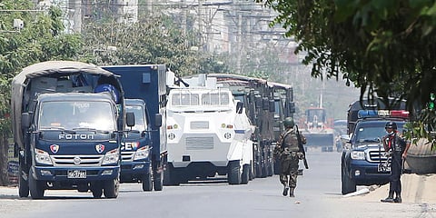 A soldier walks along a row of vehicles by security forces parked on a road in Mandalay, Myanmar. (File photo| AP)