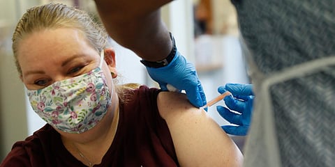 A woman at the Wheatfield surgery is given a shot of the AstraZeneca COVID-19 vaccine in England. (Photo| AP)