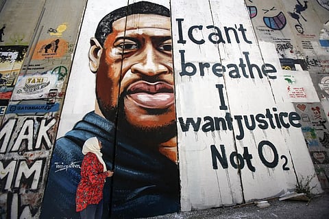 A woman looks at a mural showing the face of George Floyd, an unarmed black man who was killed by Minneapolis police. (File Photo |AFP)