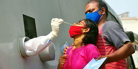 A health worker collects swab samples for Covid-19 tests at a mobile lab parked near ENT Hospital in Visakhapatnam on Thursday (Photo | G Satyanarayana, EPS)