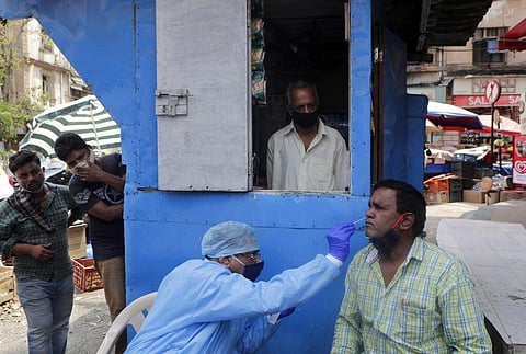 A health worker takes a nasal swab sample to test for COVID-19 at a market place in Mumbai, India, Thursday, March 18, 2021. (Photo | AP)