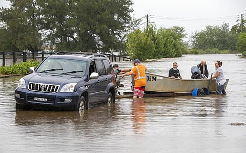 A boat is loaded back onto its trailer on a flooded road at Old Pitt Town, north west of Sydney, Australia. (Photo | AP)