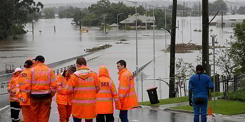 State Emergency Service personnel gather at the entrance to a submerged bridge surrounded by water from the flooded Hawkesbury River in Windsor, northwest of Sydney. (Photo| AP)
