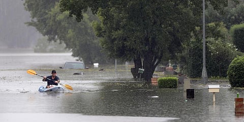 A man paddles down a flooded street in a kayak loaded with groceries for his family in Windsor, northwest of Sydney. (Photo| AP)