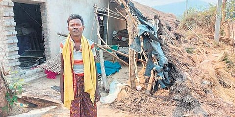 A villager outside his damaged house.