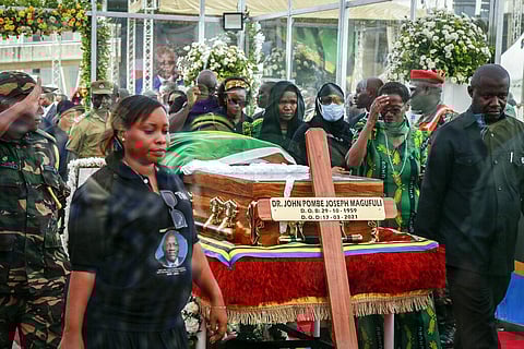 Mourners, seen through glass, pay their respects as the body of former president John Magufuli lies in state at Uhuru stadium in Dar es Salaam, Tanzania (Photo | AP)