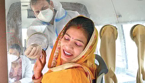 A HCW tries to take a swab sample from a woman for Covid test in Amritsar | pti