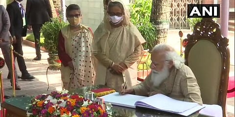 PM Narendra Modi signs the visitors' book at Sheikh Mujibur Rahman at Bangabandhu Mausoleum Complex. (Photo| ANI)