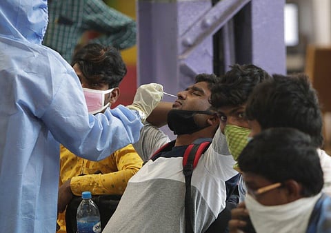 A health worker collects swab to conduct COVID-19 tests on passengers coming by long distance trains at Chhatrapati Shivaji Maharaj Terminus in Mumbai. (Photo | AP)